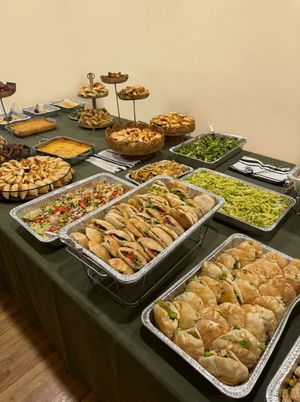 Guests' plates being filled from a Bayte Bites catering buffet