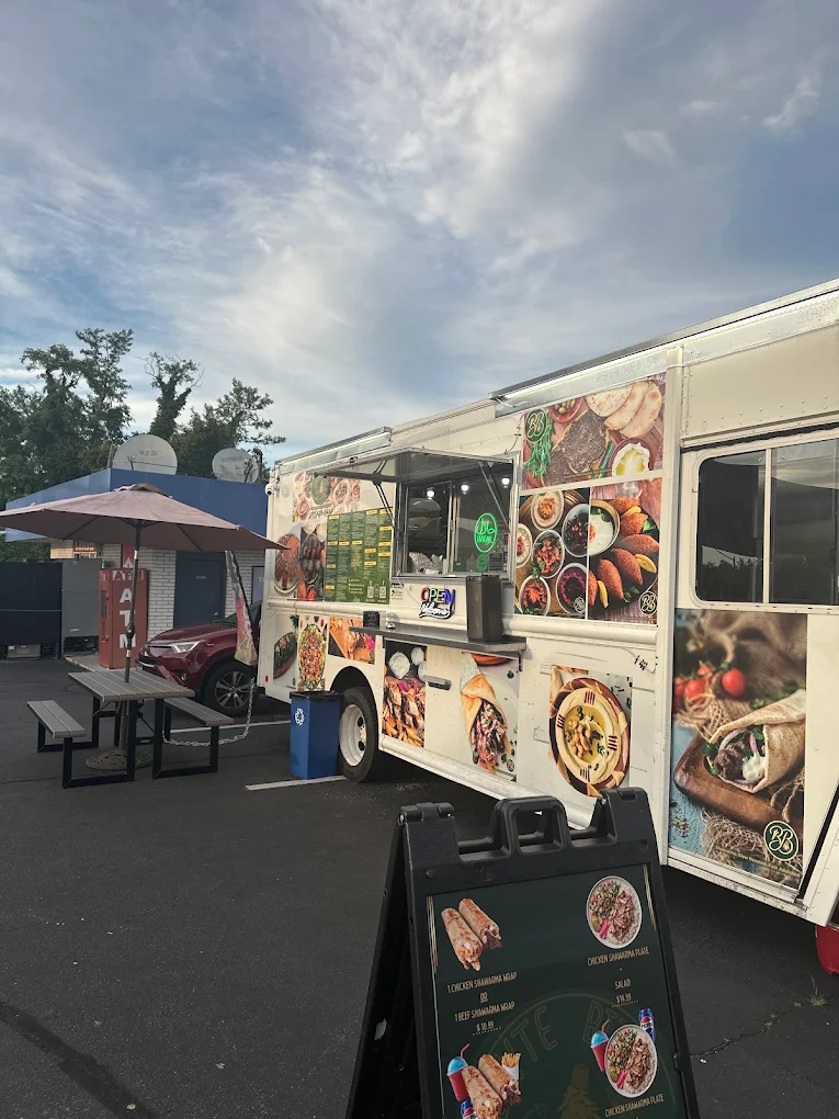 The Bayte Bites food truck parked at 7206 Little River Turnpike in Annandale, with picnic tables and outdoor seating alongside